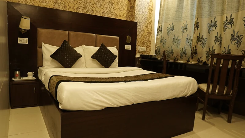 Deluxe Room queen bed with crisp linen and warm lighting at Hotel The Black Gold